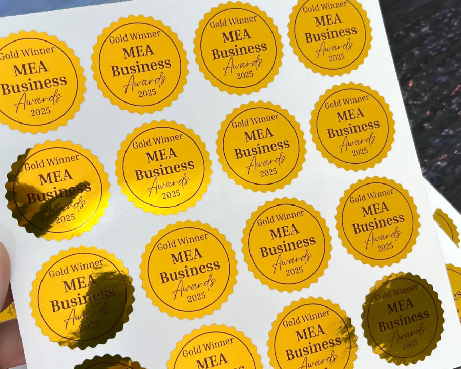 Sheet of gold foil circular stickers reading Gold Winner MEA Business Awards 2025