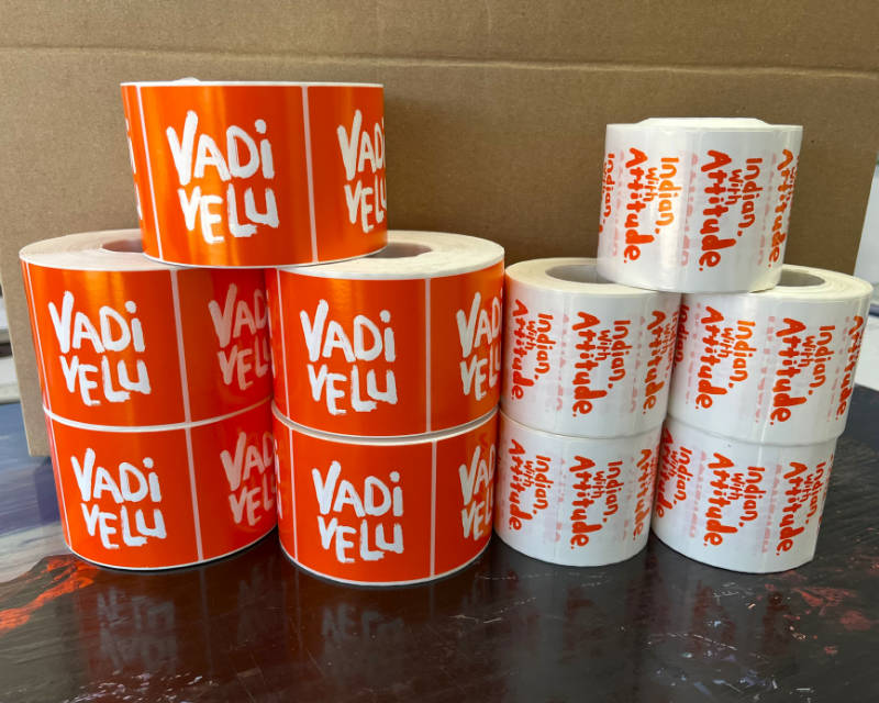 Rolls of orange and white custom branded product labels